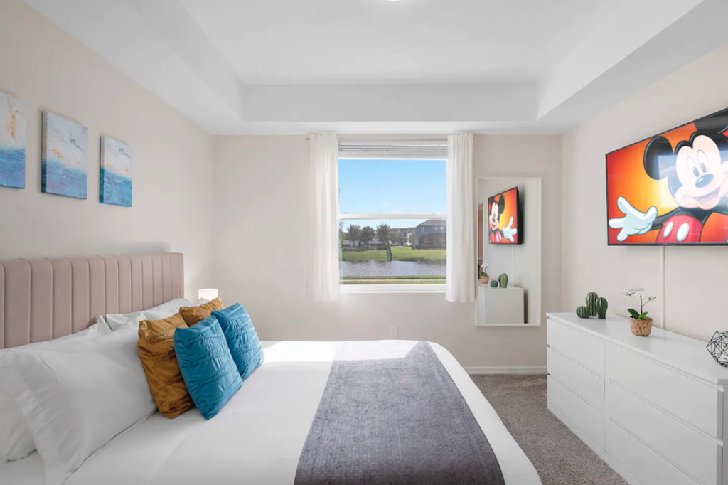 quarto claro, com cama e personagem mickey no quadro