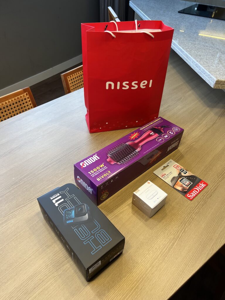 produtos eletrônicos em cima de uma mesa com sacola vermelha