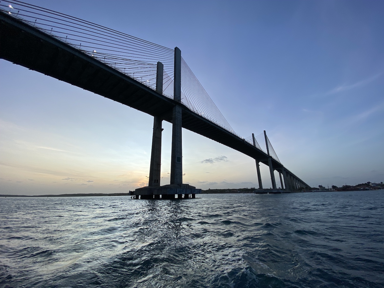 grande ponte em um rio, com o sol se pondo