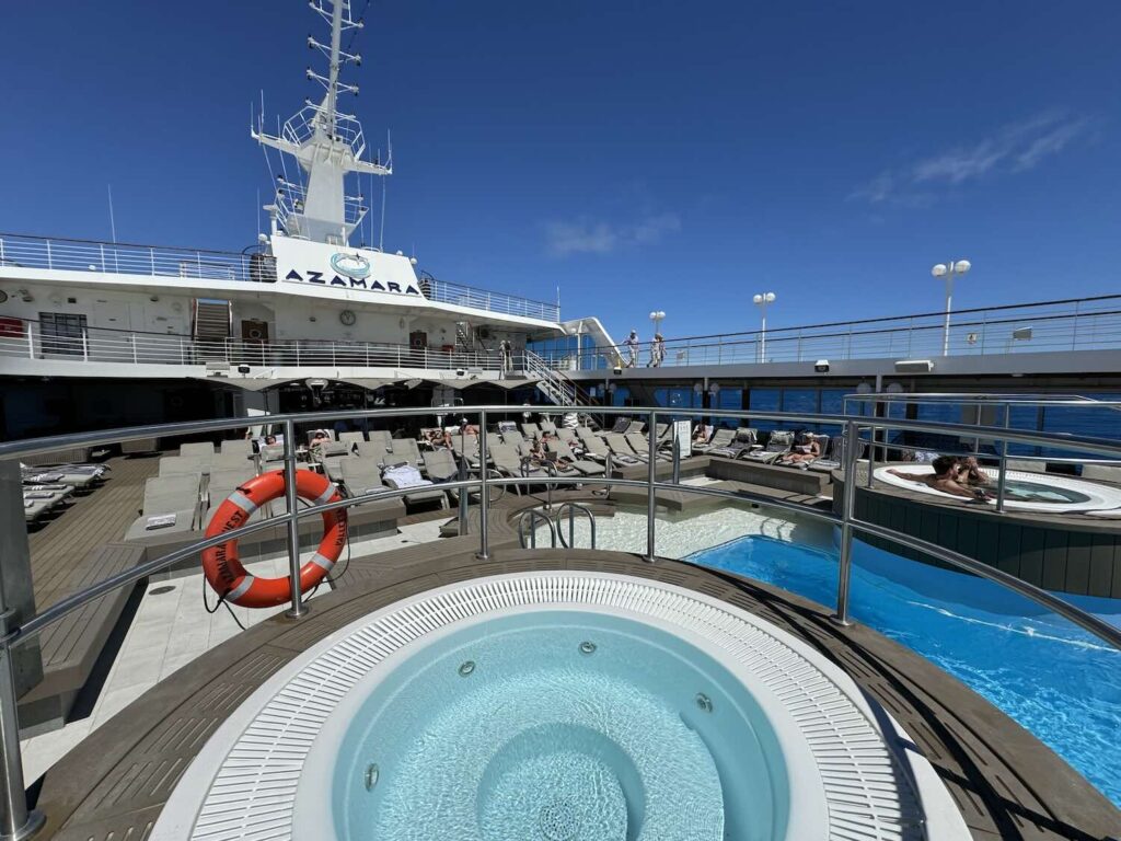 deck de um navio com piscina e céu azulado