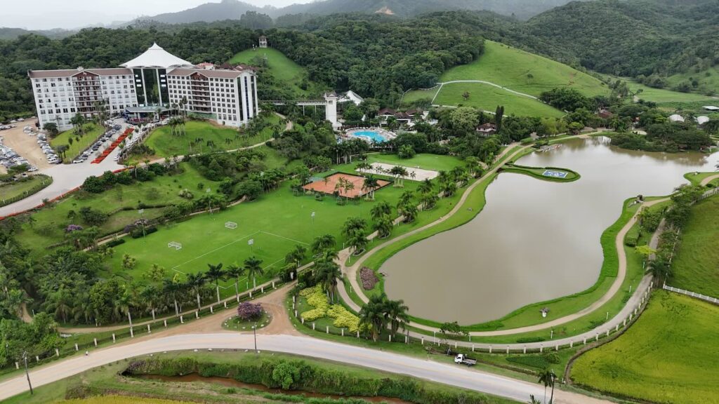 lago em meio a natureza, com prédio de hotel ao fundo