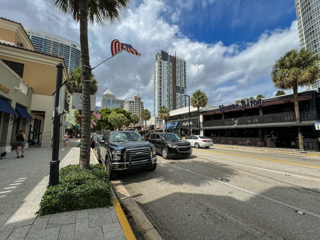 rua  em fort lauderdale com carros estacionados e circulando.