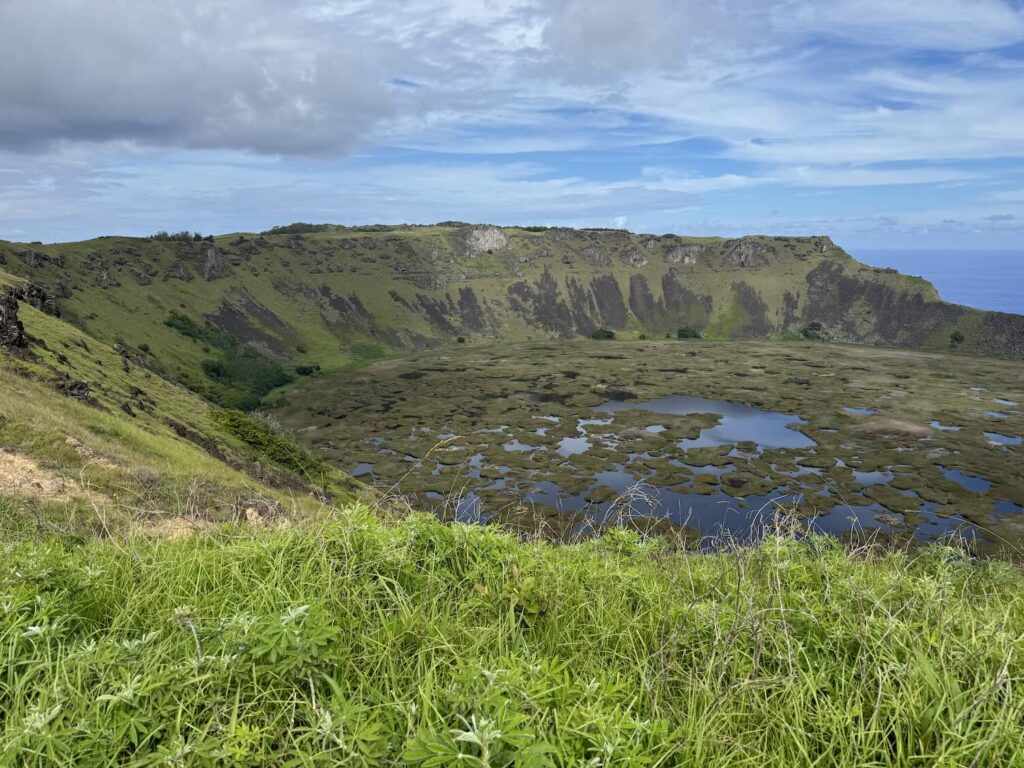 cratera de um vulcão com água e vegetação na ilha de páscoa