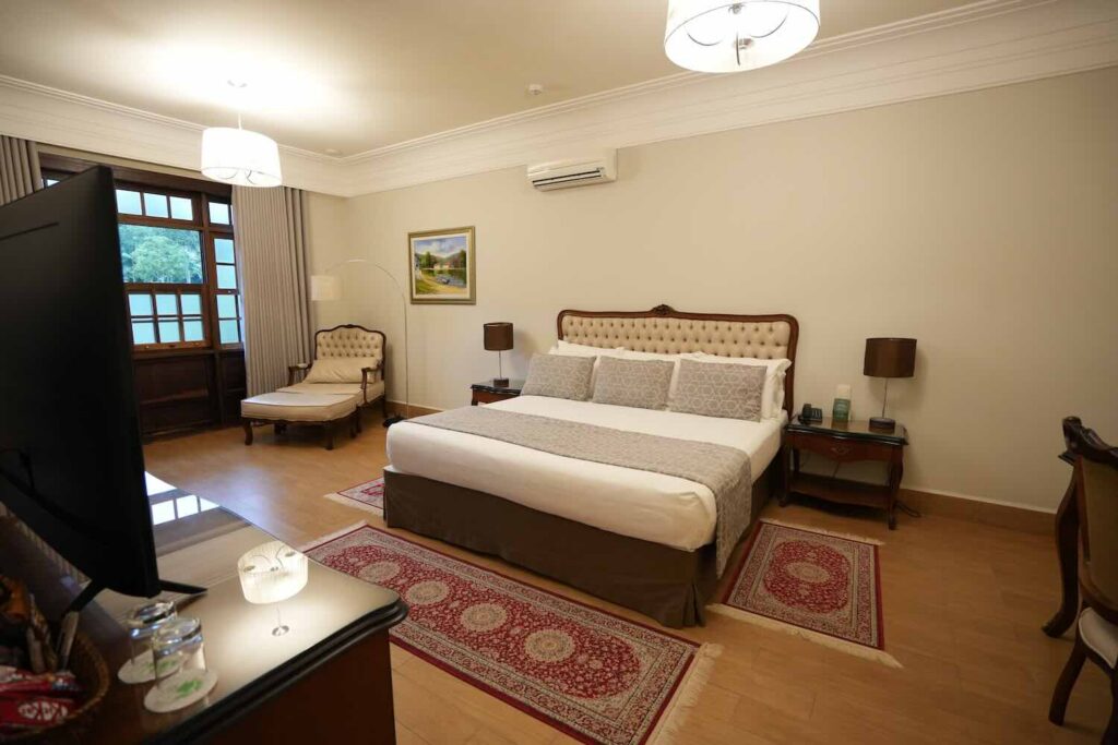 quarto de hotel com decoração clássica e cama de casal