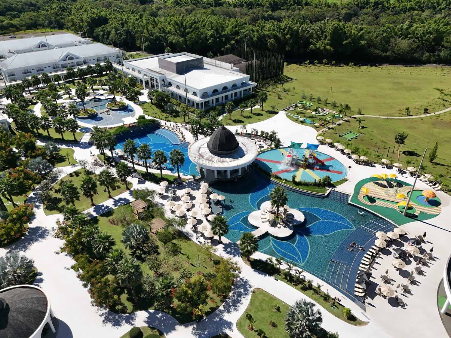 imagem aérea de diversas piscinas de um resort.