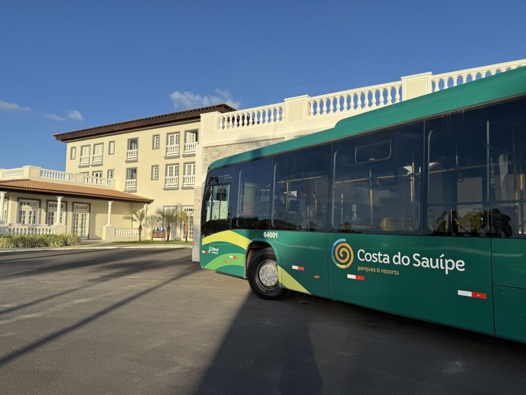 onibus verde em frente a um hotel