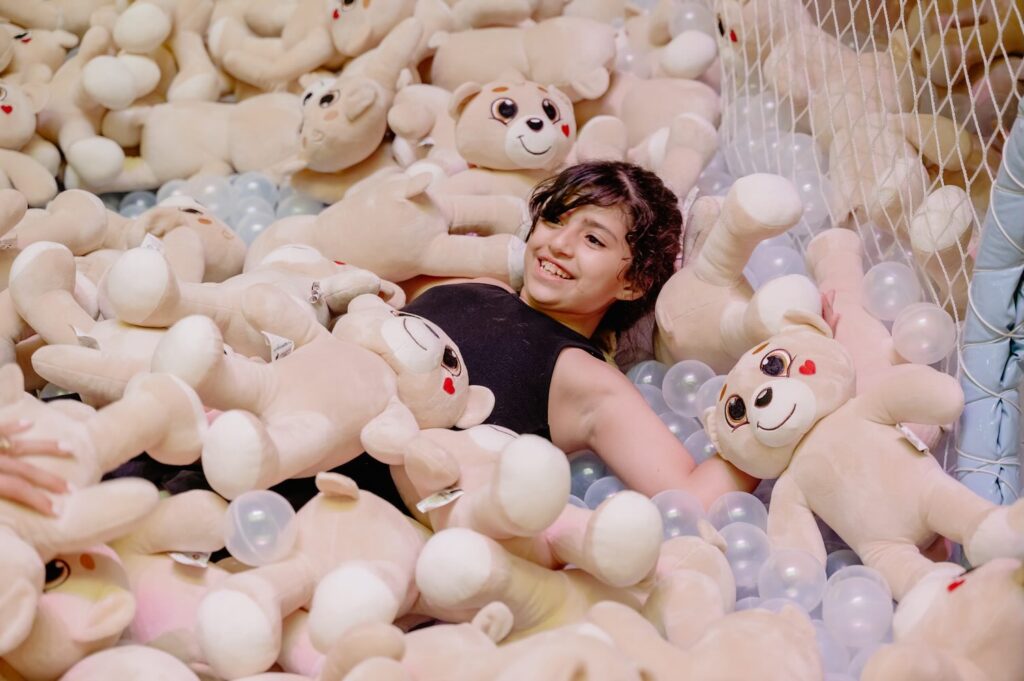 piscina de bolinha com ursos e criança sorrindo