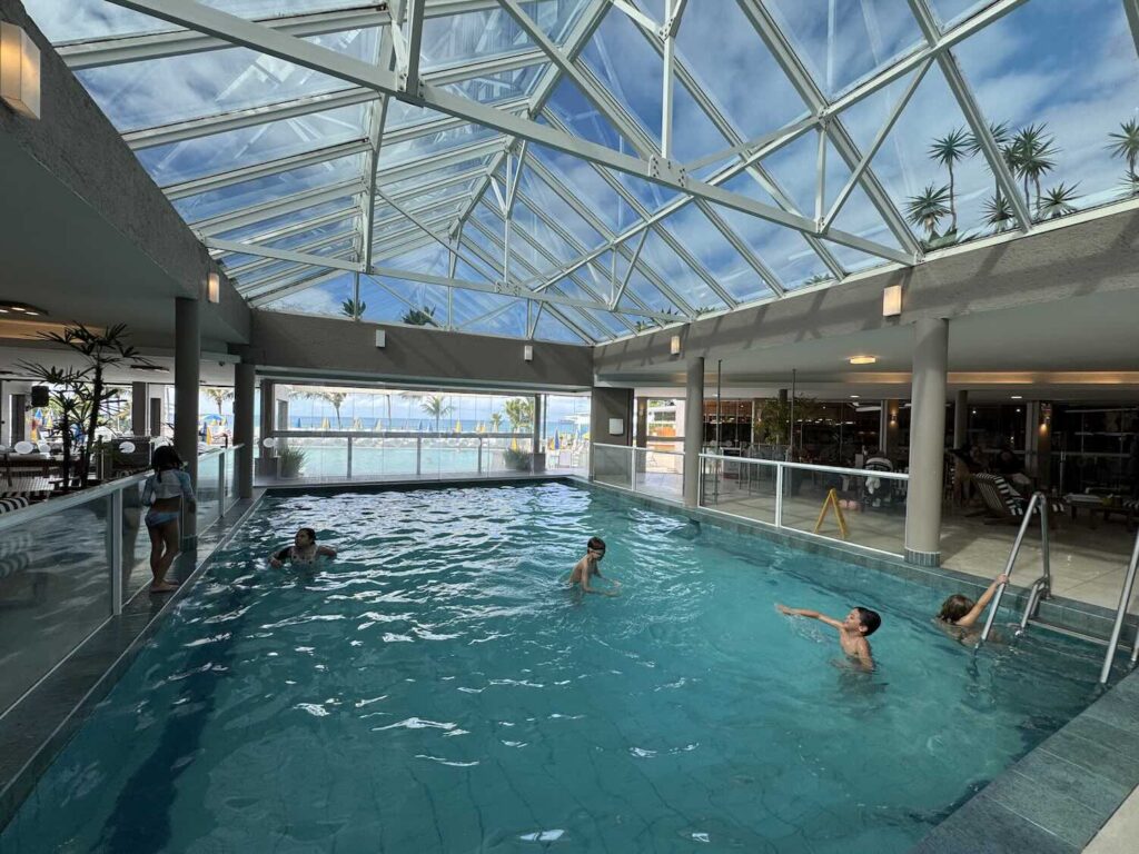 piscina coberta com crianças brincando. 