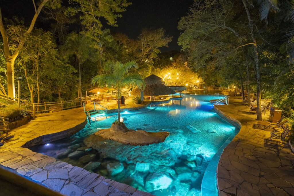 piscina natural com iluminaçnao em período noturno