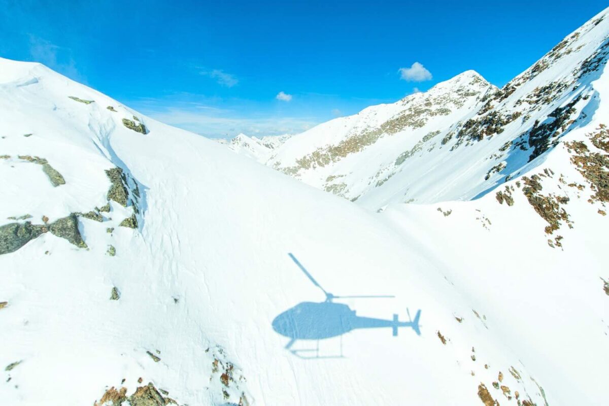 sombra de um helicóptero na montanha nevada
